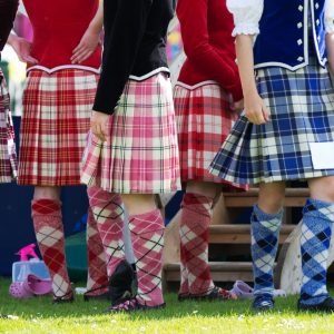 A group of Highland dancers dressed in various colored tartans.