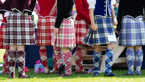A group of Highland dancers dressed in various colored tartans.