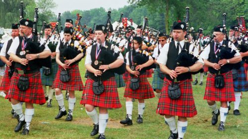 A bagpipe band marching at a Scottish festival.