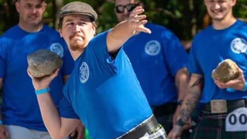 A Scottish athlete preparing to throw a rock.
